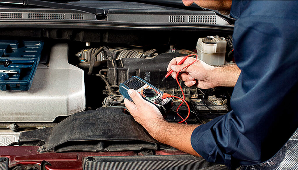 mecánico revisando sistema eléctrico del auto