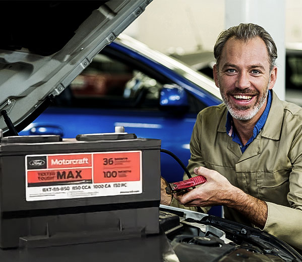 Técnico automotriz revisando batería de auto, ideal para quienes buscan financiamiento con Credimovil para mantenimiento vehicular.